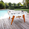 Le baby-foot Stella Outdoor blanc au bord de la piscine – Résiste aux intempéries toute l’année.